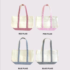 Puede incluir: Cuatro bolsas de lona con diferentes patrones de cuadros: rojo, rosa, azul y negro. Cada bolsa tiene un cuerpo blanco, un bolsillo frontal y asas y ribetes inferiores a cuadros a juego. El texto "PLAID PATTERN OPTIONS" est&aacute; en la parte superior.