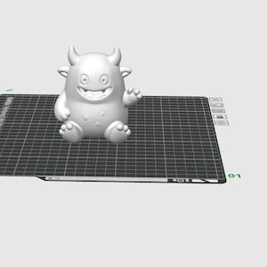 May include: A 3D-printed white cartoon monster figurine with horns, a wide smile, and a waving hand. The figure has a rounded body with three small bumps and is sitting on a black grid.