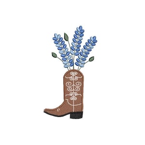 May include: A brown cowboy boot with a white design is used as a vase for a bouquet of blue flowers.