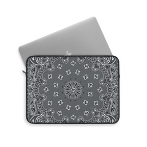 May include: A gray laptop sleeve with a black and white bandana pattern. The sleeve has a zipper closure.