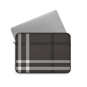 May include: A dark brown laptop sleeve with a plaid pattern in white and dark gray. The sleeve has a zipper closure and is designed to hold a laptop. A silver laptop is partially visible.