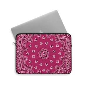 May include: A pink laptop sleeve with a white and black paisley pattern.