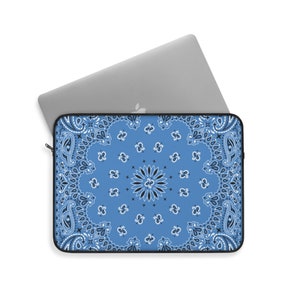 May include: A blue laptop sleeve with a white and black paisley pattern. The sleeve is made of a durable material and has a zipper closure.