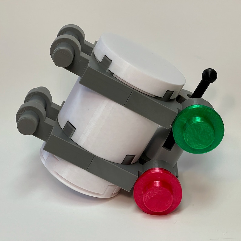 May include: A 3D-printed model featuring white cylindrical components, gray structural supports, and a black antenna. It has a green and a red button. The model is designed with a futuristic aesthetic.