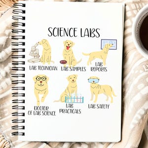 Könnte beinhalten: Ein weißes Spiralnotizbuch mit dem Titel "SCIENCE LABS". Das Notizbuch zeigt Illustrationen von gelben Labrador-Hunden in Laborsituationen, mit Textbeschriftungen wie "LAB TECHNICIAN" und "LAB SAFETY". Rechts ist eine Tasse Tee zu sehen.