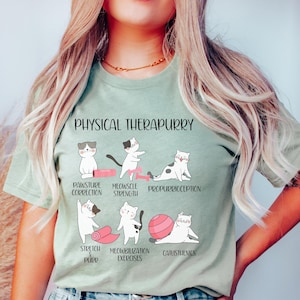 May include: A light green t-shirt with a graphic of cats doing different exercises. The text "PHYSICAL THERAPURRY" is at the top of the graphic. The text below the cats describes the exercises: "POSTURE CORRECTION", "MEOWSCLE STRENGTH", "PROPRURRICCEPTION", "STRETCH & PURR", "MOBILIZATION EXERCISES", and "CALISTHENICS".