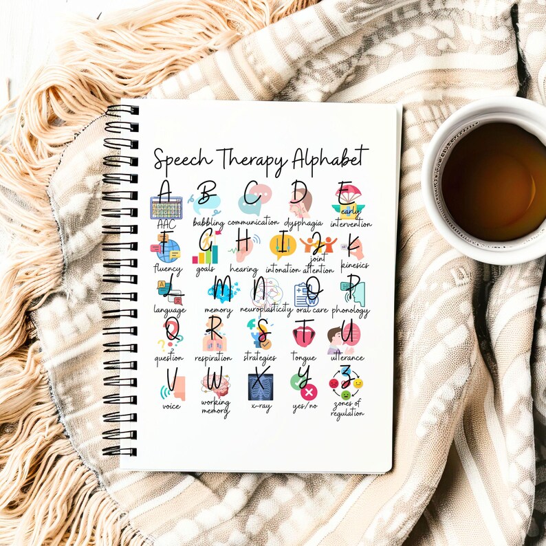 May include: A notebook titled "Speech Therapy Alphabet" displays an alphabet with speech therapy terms and illustrations. A cup of coffee sits to the right of the notebook, resting on a beige blanket.