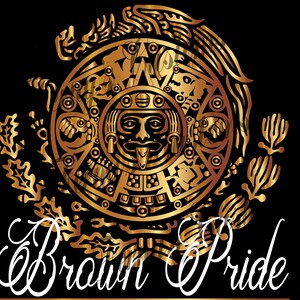 May include: A gold-colored Aztec calendar design with intricate details, set against a black background. The words "Brown Pride" are written in a white, elegant script below the calendar. The design features a central face with a protruding tongue.