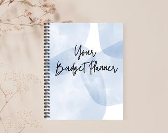 May include: A blue and white spiral bound notebook with the text "Your Budget Planner" on the front cover.