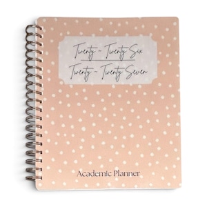 May include: A spiral-bound academic planner with a light peach cover featuring a white polka dot pattern. A central white label displays the text Twenty-Twenty Six and Twenty-Twenty Seven in black script, with Academic Planner printed below.