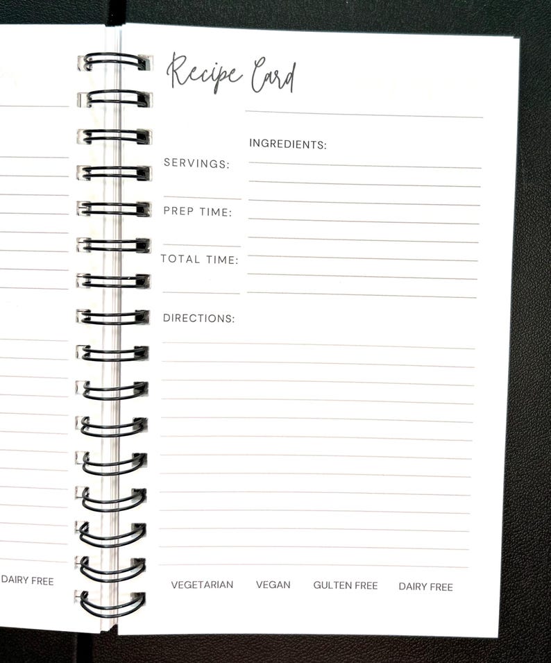May include: A white spiral-bound recipe card notebook with black text. The page features fields for Recipe Card, Servings, Prep Time, Total Time, Ingredients, and Directions. Bottom labels include Vegetarian, Vegan, Gluten Free, and Dairy Free.