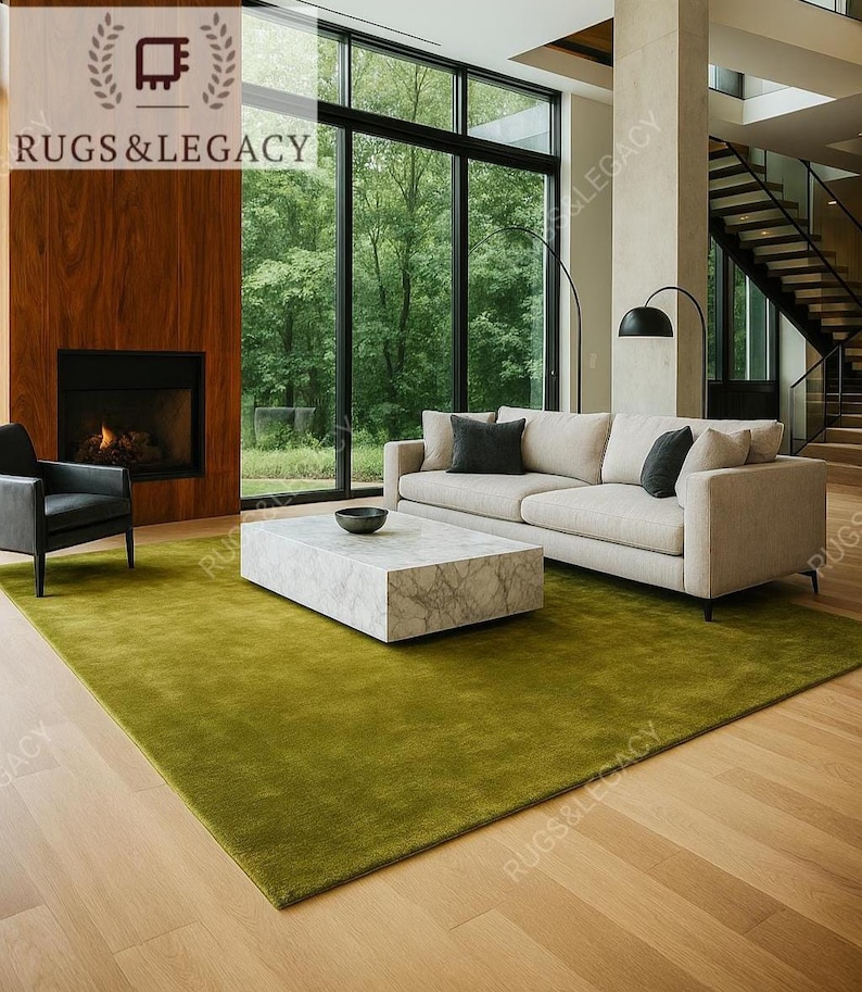 Solid green wool area rug styled in modern living room under neutral sofa and marble coffee table, showcasing how the rug enhances contemporary interiors.