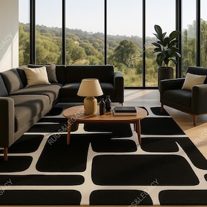 Op de afbeelding: Een moderne woonkamer met een zwart-wit geometrisch patroon tapijt. De kamer heeft een donkergrijze hoekbank, een houten salontafel en een zwarte fauteuil. Een lamp en decoratieve items staan op de tafel. Grote ramen bieden uitzicht op een groen landschap.