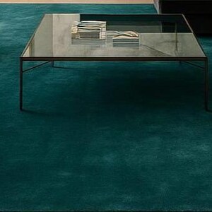 Close up texture shot of plush solid green wool rug for bedroom decor