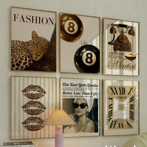 May include: A set of framed prints with a fashion theme. The artwork features a leopard, billiard balls, a telephone, lips, a woman with sunglasses, and a clock. The frames are gold-toned, and the style is vintage and chic.