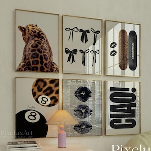 May include: A set of framed wall art with diverse designs. Includes a leopard print, black bows, a skateboard, lips, a pool ball, and the word "CIAO!". The art pieces are displayed above a white cabinet.