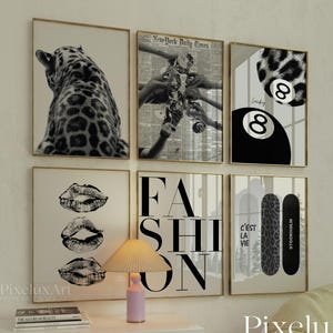 Puede incluir: Una colección de arte mural enmarcado con imágenes en blanco y negro. El arte incluye un leopardo, labios, la palabra "FASHION", una bola de billar y patinetas. También es visible la frase "C'est la vie".