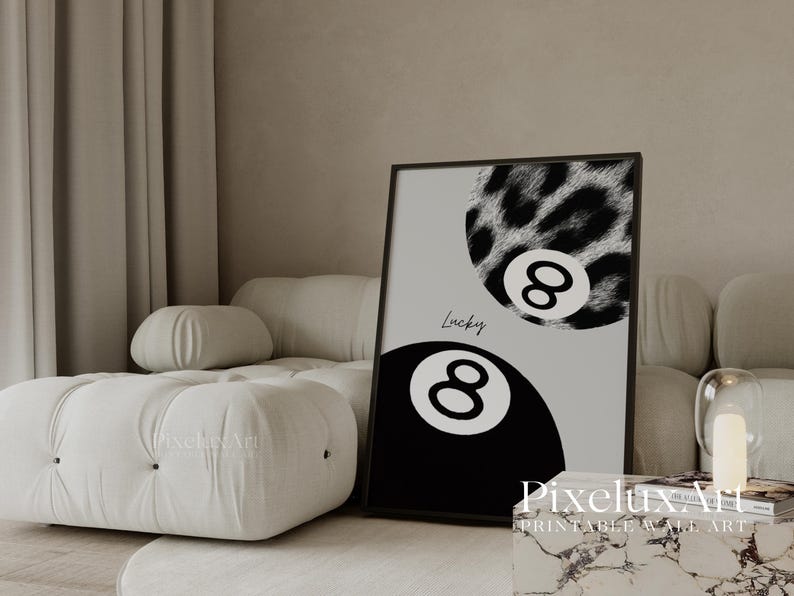 K&ouml;nnte beinhalten: Schwarz gerahmtes Wandbild mit zwei Billardkugeln mit der Nummer 8. Eine Kugel ist schwarz, die andere hat ein Leopardenmuster. Das Wort "Lucky" ist kursiv geschrieben. Der Hintergrund ist hellgrau.