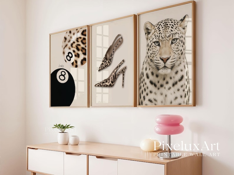 May include: Three framed wall art prints. One features a leopard print 8-ball, another shows leopard print high heels, and the third is a close-up of a leopard's face. The frames are gold-toned.