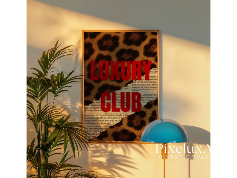 May include: A framed wall art print with a leopard print background and the words "LUXURY CLUB" in bold red letters. The artwork has a torn paper effect, revealing a newspaper-style print underneath. The print is displayed on a wall.