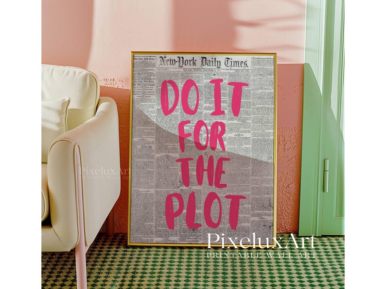 Puede incluir: Una impresi&oacute;n enmarcada con el texto "DO IT FOR THE PLOT" en rosa brillante sobre un fondo de peri&oacute;dico vintage. La impresi&oacute;n est&aacute; en un marco dorado y se muestra contra una pared rosa.