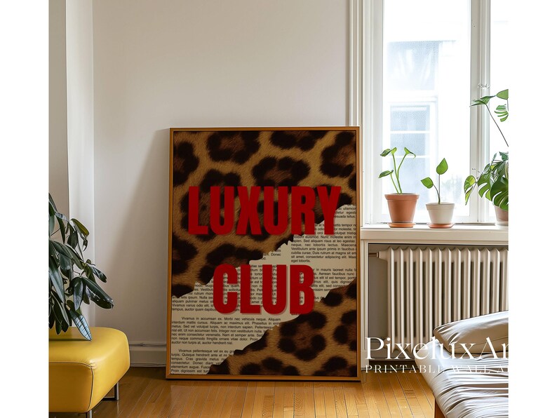 May include: A framed print featuring the words "LUXURY CLUB" in bold red letters against a leopard print background. The design incorporates torn paper elements, adding a textured effect. The artwork is displayed in a room with natural light.