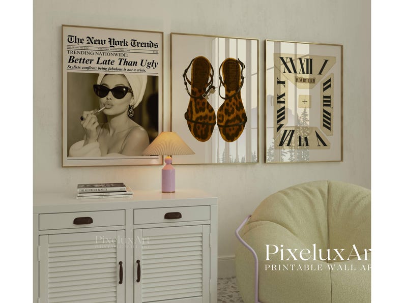 May include: Three framed wall art prints. The first features a vintage newspaper headline that reads "Better Late Than Ugly." The second shows a pair of leopard print sandals. The third print has a clock design. A small lamp and a white cabinet are in the foreground.