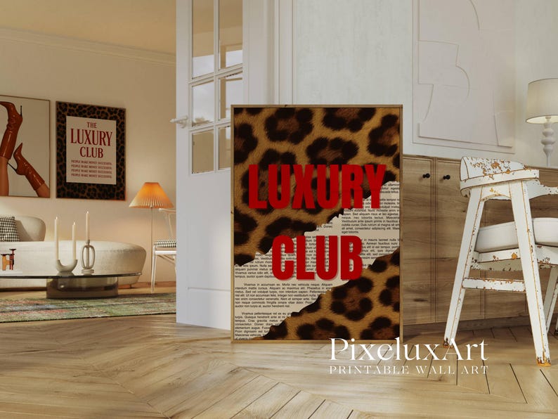 May include: A framed print with a leopard print background and the words "LUXURY CLUB" in red. The print has a torn paper effect, revealing a newspaper-style background. The image is in a room with other framed art and furniture.
