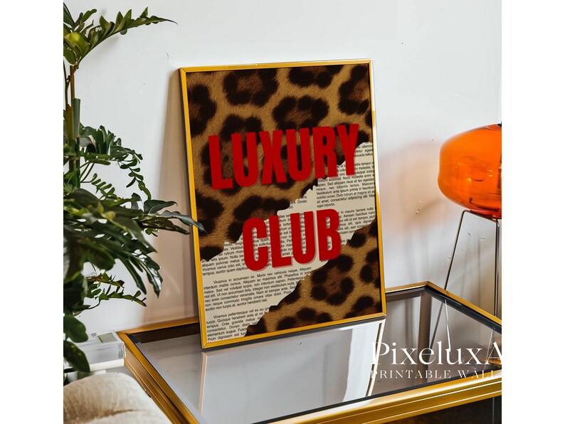 May include: A framed print with a leopard print background and the words "LUXURY CLUB" in red. The print has a gold frame and is displayed on a mirrored surface. The overall theme is fashion and luxury.