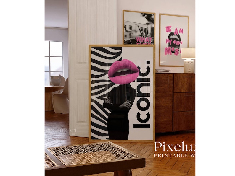 May include: A framed art print featuring a woman's silhouette with a pink lip design and the word "Iconic." The background has a zebra stripe pattern. Two other framed prints are visible in the background.