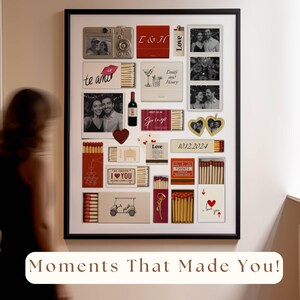 May include: A collage of photos and matchboxes in a black frame. The photos show a couple and the matchboxes have various designs, including hearts, flowers, and the text "te amo". The frame is hanging on a white wall. The text "Moments That Made You!" is written below the frame.