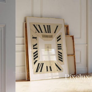 May include: A large framed print featuring a clock face design with Roman numerals and the words "LUXURY CLUB". The artwork is in neutral tones of beige and black, leaning against a wall in a room with hardwood floors.