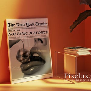 May include: A framed print featuring a newspaper-style design with the headline "The New York Trends." The image shows a close-up of a mouth with a disco ball. The text reads "NOT PANIC, JUST DISCO."