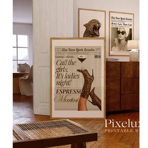 May include: Three framed prints with a fashion theme. The largest print features a newspaper-style design with the text "Call the girls. It's ladies night! Espresso Martini." The other prints show a leopard and a woman with sunglasses.