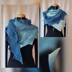 Può includere: Uno scialle blu all'uncinetto fatto a mano, esposto su un manichino. Lo scialle presenta una sfumatura di blu, dal blu navy scuro al turchese chiaro. L'intricato design traforato e i bordi smerlati aggiungono consistenza e interesse visivo a questo accessorio.