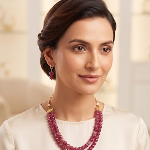 Peut inclure: Un collier à deux rangs composé de perles de pierres précieuses facettées rouge-rose foncé avec des intercalaires en métal doré, accompagné d'une paire de boucles d'oreilles pendantes formées de deux perles facettées sur des crochets dorés.