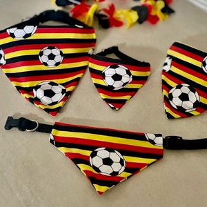 Könnte beinhalten: Drei Hundehalstücher in Schwarz, Rot und Gelb mit einem Fußballmuster. Die Halstücher sind in verschiedenen Größen und haben verstellbare Bänder.