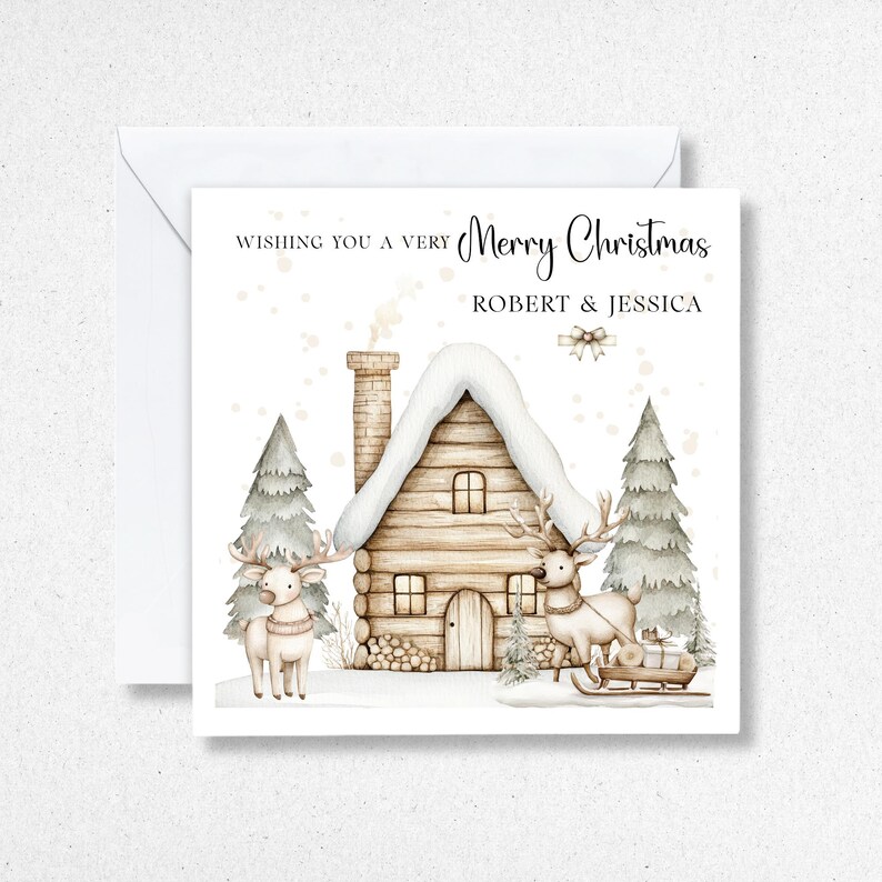 K&ouml;nnte beinhalten: Weihnachtskarte mit einer Aquarellillustration eines schneebedeckten Blockhauses, zwei Rentieren und Tannenb&auml;umen. Die Karte tr&auml;gt die Aufschrift "Wishing you a very Merry Christmas" und die Namen "ROBERT & JESSICA".