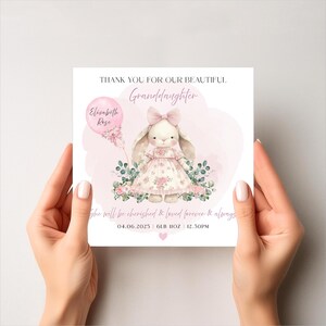Puede incluir: Tarjeta de felicitaci&oacute;n con una ilustraci&oacute;n en acuarela de un conejito con un vestido y un globo. La tarjeta dice "Gracias por nuestra hermosa nieta". El globo dice "Elizabeth Rose". La tarjeta tambi&eacute;n incluye la fecha, el peso y la hora.