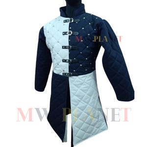 May include: A black and white quilted jacket with a medieval design. The jacket features a high collar, long sleeves, and a front closure with buckles. The jacket is decorated with rivets and has a diamond-shaped quilting pattern.