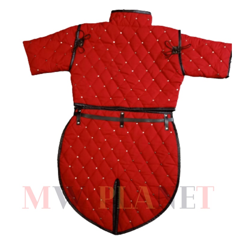 K&ouml;nnte beinhalten: Rotes gestepptes Gambeson mit kurzen &Auml;rmeln und einem Rock. Das Gambeson hat einen schwarzen Lederg&uuml;rtel und ist mit kleinen Metallnieten verziert.