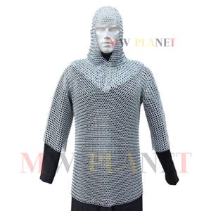 Puede incluir: Una camisa de cota de malla plateada con capucha. La cota de malla está hecha de pequeños anillos de metal entrelazados. La camisa es de manga larga y tiene cuello en V.