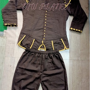 May include: A brown quilted jacket with yellow trim and a matching pair of brown shorts. The jacket has a high collar and a button-up front. The shorts have an elastic waistband.