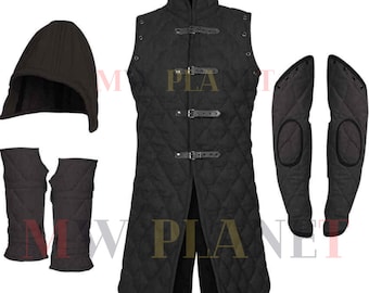 May include: A black quilted gambeson with a hood, arm guards, and elbow pads. The gambeson has a high collar and is fastened with buckles. The arm guards and elbow pads are also quilted and are black.