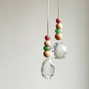 May include: Two crystal suncatchers hanging from strings with wooden beads and green and red beads.