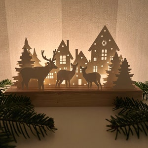 Forest of lights light house light house decorative house Christmas decoration on wooden strip forest animals city of lights