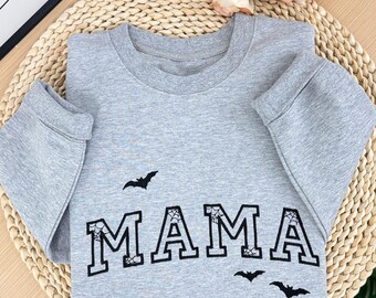 May include: Grey sweatshirt with the word "MAMA" in black block letters with spiderwebs and bats.