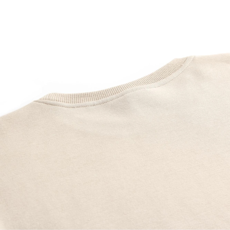 Puede incluir: Una camiseta lisa de color beige claro con cuello redondo.