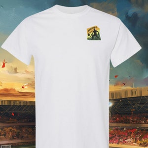 May include: White t-shirt with a green, yellow and black embroidered patch that says "Unbreakable Wall Stand Tall" and features a silhouette of a football player kicking a ball.