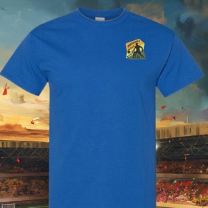 May include: A royal blue t-shirt with a small embroidered patch on the front. The patch features a silhouette of a person playing football with the text "Unbreakable Wall Stand Tall".